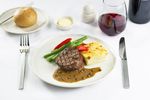 Chargrilled beef fillet in green peppercorn sauce, with seasoned vegetables and gratin